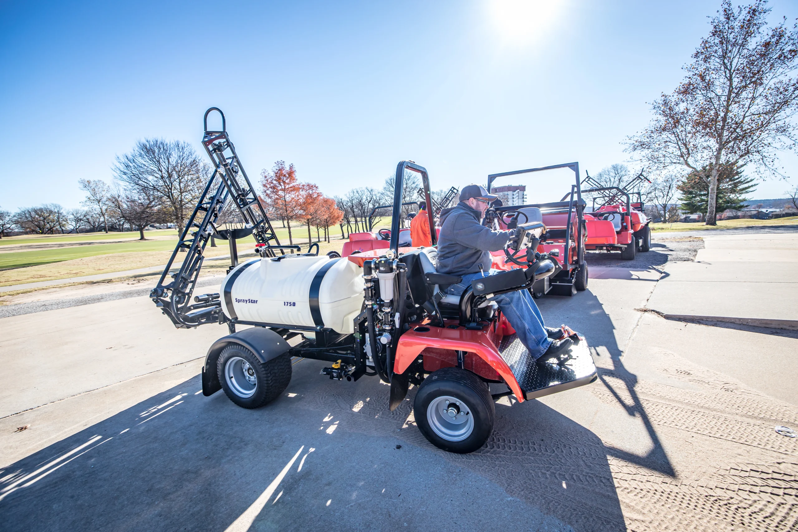 Spray Star 1750 turf sprayer in operation, featuring a large elliptical tank and advanced spray boom, with operator seated at controls, set in a turf management environment.